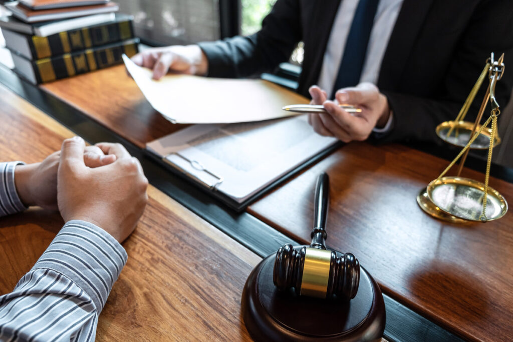 Male lawyer discussing negotiation legal case with client meeting with document contact in courtroom, law and justice concept.