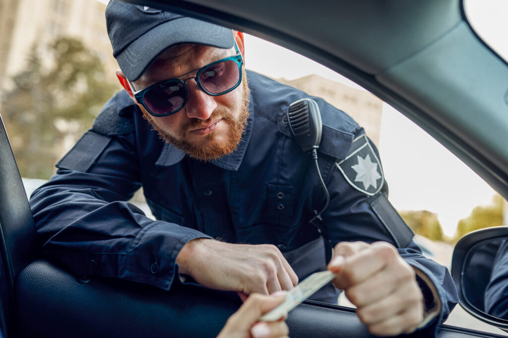 Male police officer takes the driver's license from female driver. Policeman in uniform protect the law, registration of an offense. Cop works on city street, order and justice control