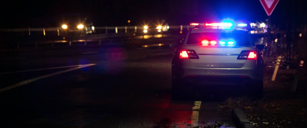 Police lights at night on a Colorado highway, representing a traffic stop for repeat speeding violations